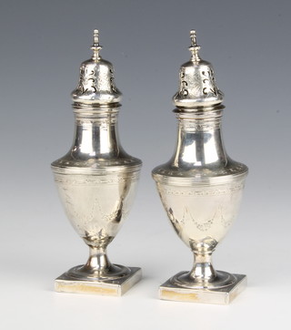 A pair of Georgian silver vase shaped peppers with chased armorial on square bases, 15.5cm, 190 grams