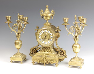 Fritz Marti, a 19th Century French 3 piece 8 day striking clock garniture, striking on a bell with porcelain dial inset numerals marked Marcireau Portier, contained in a gilt metal drum case surmounted by a lidded urn, complete with key and pendulum, together with a pair of matching 3 light candelabra  