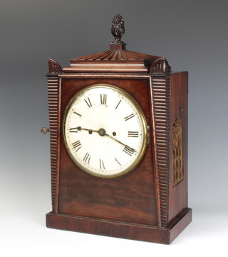 A Georgian double fusee striking bracket clock with 21cm circular dial with Roman numerals, having a 13cm arched brass back plate, contained in a mahogany case surmounted by an urn and with brass grilled sides 50cm h x 32cm w x 17cm d 