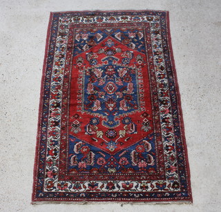 A Persian red and blue ground Behbahan rug with central medallion 202cm x 127cm 