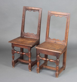 A matched pair of 16th Century style oak and elm bar back stools raised on turned supports with H framed stretcher 