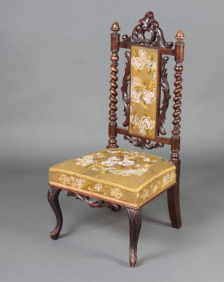 A Victorian Carolean style carved walnut nursing chair with spiral turned decoration, the seat and back upholstered in Berlin woolwork, raised on cabriole supports  