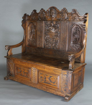 A 19th Century heavily carved oak settle the shaped raised back carved armorial decoration and with mask arms 149cm h x 151cm w x 60cm d 