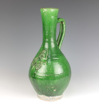 An 18th/19th century green slip glazed bulbous bodied ewer decorated with leaves 37cm