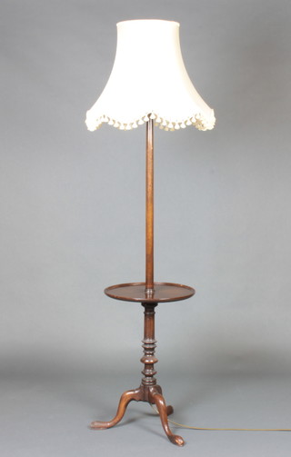 A Queen Anne style turned mahogany standard lamp the base incorporating a wine table, raised on a pillar and tripod base  