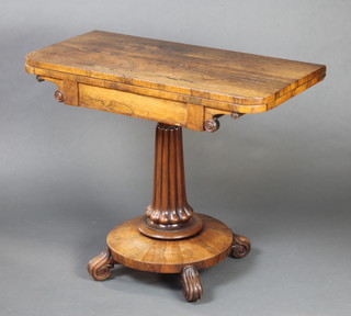 A Regency rosewood D shaped card table raised on turned and fluted column with circular base and scroll feet 75cm h x 92cm w x 45cm d 
