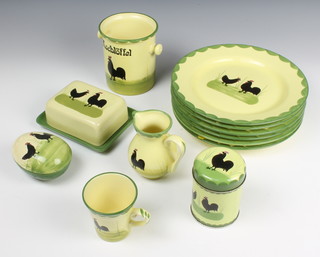 A German part dinner service decorated with cockerels comprising 5 bowls, 4 tea cups, 4 saucers, 5 medium plates, 6 large plates, an ovoid box and cover, a jug, a conserve pot and cover, a jar, dish, a butter dish and cover, tin and place mat 
