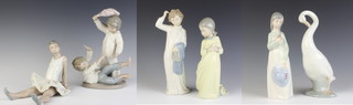 A Nao figure of a lady standing beside a plinth with a ewer 35cm, ditto of a girl in a yellow dress 26cm, ditto boy 27cm, goose 23cm, girl with hat 23cm, a seated ballerina 17cm and two boys 24cm