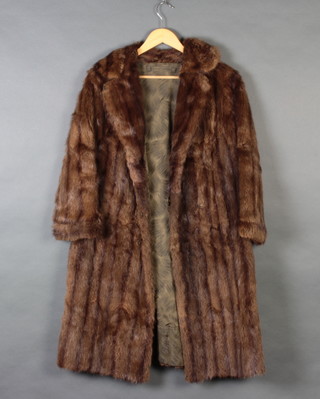 A lady's brown musquash full length coat 