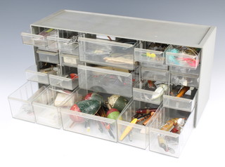 A bank of 23 drawers containing vintage fishing lures, flies, salmon and trout floats including cork, pipe floats etc