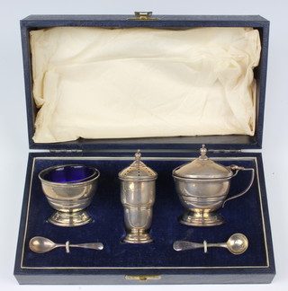 A silver 3 piece condiment with blue glass liners and 2 spoons, Birmingham 1946, 100 grams 
