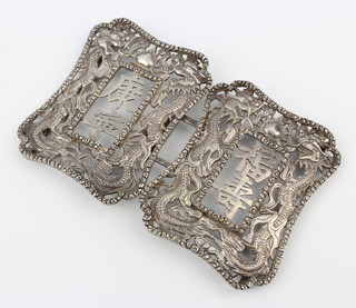 A Chinese cast and chaste silver buckle decorated with dragons chasing the flaming pearl 12cm x 8cm, 44 grams