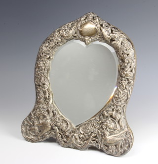 A Victorian repousse silver heart shaped photograph frame decorated with birds, mythical masks and flowers, engraved Lily, London 1899, maker William Comyns 28cm x 24cm 