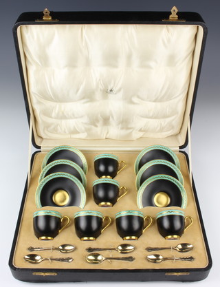A Royal Worcester coffee set the black ground with turquoise and gilt key pattern decoration comprising 6 coffee cups and saucers together with 6 silver coffee spoons, Sheffield 1931, in a fitted case 