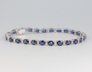 An 18ct white gold sapphire and diamond line bracelet, the sapphires approx. 11.22ct, the diamonds approx 0.65ct, 17.5cm long 