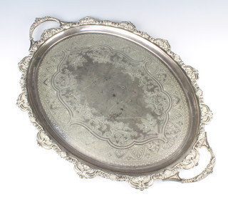 An Edwardian oval silver tray with fancy shell rim and twin handles, engraved with flowers and scrolls, Sheffield 1901, maker Joseph Rodgers & Sons 69cm, 3494 grams 