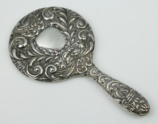 A repousse silver hand mirror decorated with scrolls, flowers and masks 24cm 