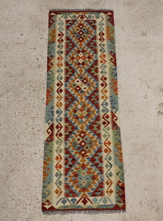 A red and green ground Kilim runner with 6 stylised diamonds to the centre 197cm x 63cm