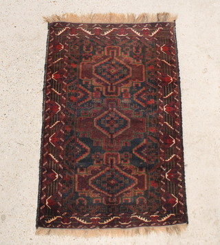 A black and brown ground Belouche rug having 3 medallions to the centre 140cm x 87cm 
