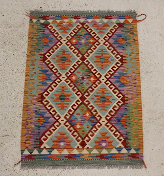 A green and tan ground Kilim rug with geometric designs to the centre 122cm x 84cm 
