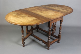 An 18th/19th Century oak gateleg drop flap dining table raised on turned supports 72cm h x 91cm w x 45cm when closed x 64cm when open 