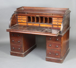 A Victorian mahogany cylinder bureau, the upper section with 3/4 gallery, the fall revealing a well fitted interior with pigeon holes and drawers, the pedestal fitted 6 drawers with tore handles 116cm h x 135cm w x 77cm d 