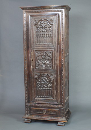 An 18th/19th Century Flemish carved black oak cabinet with moulded cornice and shelved interior, the base fitted 1 long drawer raised on square supports 190cm h x 81cm w x 50cm d 