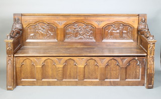 A Victorian heavily carved oak settle, the raised back carved interior scenes, the arms carved reclining Cromwellian figures with tortoise and bird at feet, having a carved Gothic arched panel to the front 97cm h x 201cm l x 63cm d 