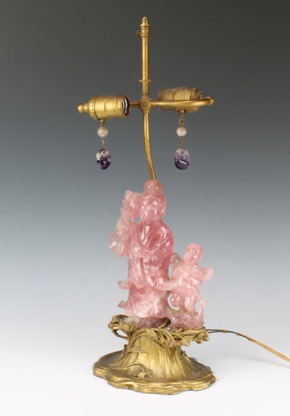 A 19th Century rose quartz carving of Guan Yin and an attendant mounted on a gilt wooden base converted to electricity with 2 carved amethyst light pulls 53cm 