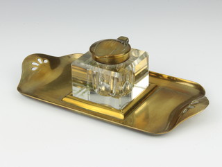 An Edwardian Art Nouveau pierced brass twin handled standish, the centre with cut glass inkwell with brass lid, the interior marked PCM 158180 5cm x 22cm x 11cm 