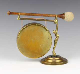 An Art Deco brass tea gong supported by a figure of a standing naked lady 18cm x 24cm 