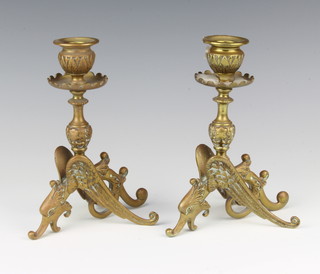 A pair of Victorian brass candlesticks supported by figures of griffins 18cm 