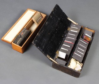Two shallow pine boxes containing a collection of coloured magic lantern slides 