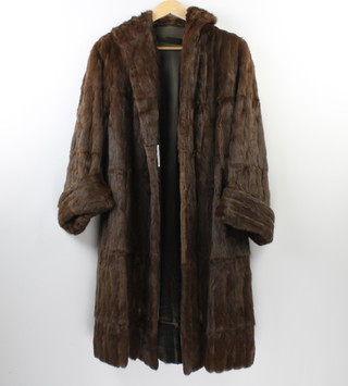 A lady's full length brown fur coat and a mink cape 

