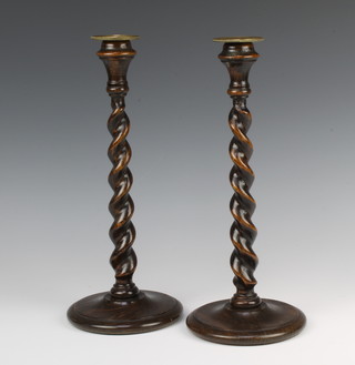 A pair of oak spiral turned candlesticks with detachable brass sconces 33cm 
