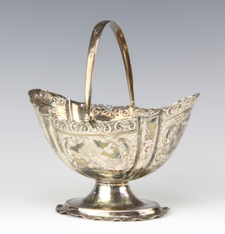 A Victorian repousse silver boat shaped sugar basket with swing handle with scroll decoration Sheffield 1894, 18cm to the handle, 225 grams 