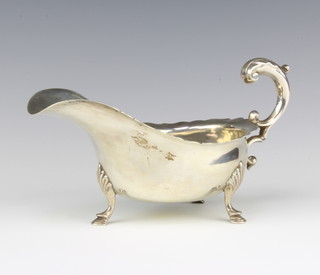 A silver sauce boat with cut rim and S scroll handle on hoof feet London 1921, 19cm, 190 grams 