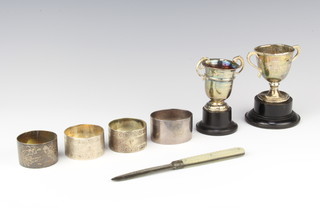 A silver napkin ring Sheffield 1958, 3 others, 2 trophy cups and a fruit knife, weighable silver 195 grams 