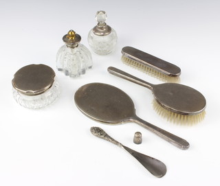 A silver engine turned brush set comprising hairbrush, clothes brush and hand mirror, 3 mounted bottles, shoe shorn and 2 thimbles