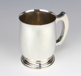 A silver mug of bulbous form with angular handle Birmingham 1947, 13cm, 390 grams
