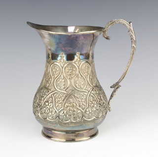 An Indian repousse silver baluster jug with floral motifs and S scroll handle, 17cm, 445 grams