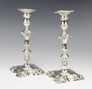 A pair of George III cast silver candlesticks with waisted stems and acanthus decoration London 1764, maker J H, with engraved armorials, 22cm 1100 grams