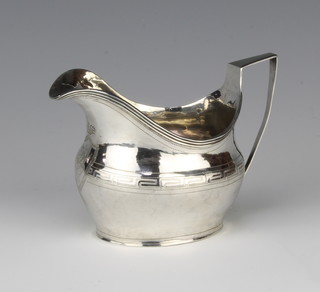 A George III silver cream jug of baluster form with cased monogram, rubbed marks 84 grams