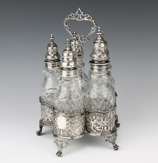 A George III silver bottle stand with pierced knees and claw and ball feet London 1775, together with 5 cut glass mounted bottles 28cm