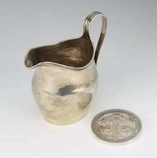 A George III silver cream jug, monogrammed 10cm, London 1802, together with a silver presentation medallion 140 grams