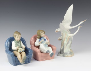 A Nao figure group of flying cranes 10cm and a pair of Nao figures of children in armchairs 