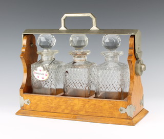 A pair of Edwardian silver plated mounted oak tantalus containing 3 square cut spirit decanters 