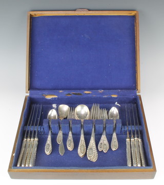 A canteen of sterling silver cutlery with fancy scroll handles, comprising 8 teaspoons, 8 dessert forks, 8 dinner forks, 7 soup spoons, a preserve spoon and butter knife together with 8 silver handled dinner knives, contained in a canteen, 1250 grams 