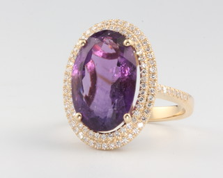 A 14ct yellow gold oval cut amethyst approx 8ct surrounded by brilliant cut diamonds approx. 0.7ct, size M 1/2 