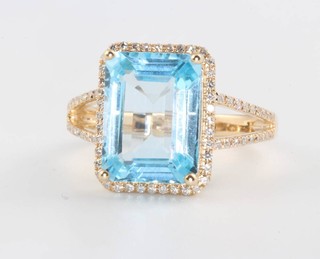 A 14ct yellow gold blue topaz and diamond ring, the centre stone approx. 6.18ct, surrounded by brilliant cut diamonds approx. 0.5ct, size M 1/2